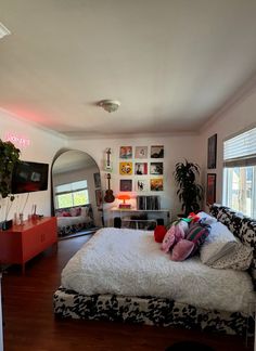 a bed room with a neatly made bed and a large mirror on the wall above it