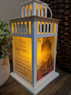 a candle with a photo on it sitting next to a potted plant