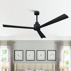 a bedroom with a bed, ceiling fan and two pictures on the wall above it