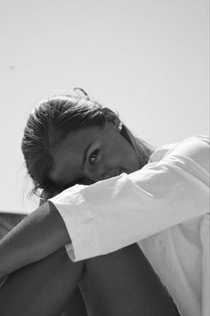 a black and white photo of a woman sitting on the ground