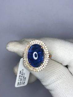 "Natural Tanzanite Ring, 14K Solid Gold Ring, 14k Gold Tanzanite Ring, Engagement Ring, Gift for her, June Birthstone Ring, Wedding Ring Gem: Tanzanite Cabochon  Gem size & shape: 12x18 mm and oval Gem weight: 13.60 Carats One of a kind engagement ring for a woman\" - that is what comes to mind when you see this ring. We absolutely believe that your partner will fall in love with  this piece, the same way our women's team falls in love with it. RING TYPE - ENGAGEMENT RING,PROMISE RING,BRIDAL RING,SOLITAIRE RING,WEDDING RING,ANNIVERSARY RING,CUSTOM RING,FINE JEWELRY,STACKING RING,GIFT FOR HER,BIRTHDAY RING \"HANDMADE WITH LOVE\" MADE IN INDIA YOUR ORDER IS MADE TO ORDER.  CUSTOMIZATION  Main stone: Tanzanite cabochon  Main stone weight: Approx 13.60 ct Metal type: 14k Yellow Gold  Side Ston Gia Certified Yellow Gold Sapphire Ring With Diamonds, Exquisite Tanzanite Rings With Prong Setting, Yellow Gold Diamond Ring With Tanzanite In Prong Setting, Yellow Gold Gemstones With Halo Setting, Gia Certified Yellow Gold Sapphire Ring, Round Yellow Gold Gemstones With Halo Setting, 14k Yellow Gold Sapphire Ring With Halo, Yellow Gold Topaz Ring With Diamond Halo, Yellow Gold Tanzanite Diamond Ring With Halo Setting