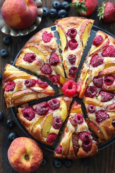 a sliced cake with raspberries and peaches on it