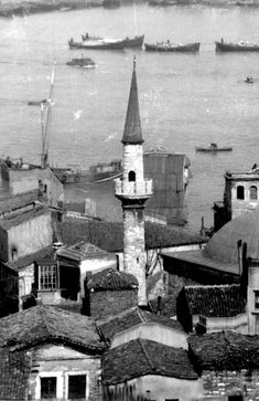 an old black and white photo of a city with lots of boats in the water