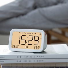 an alarm clock sitting on top of a stack of books