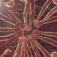 a group of people standing in a circle with their hands on top of each other