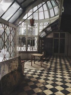 an empty room with a checkered floor and large glass windows on the ceiling is seen in this image