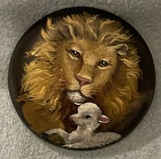 a lion and lamb are depicted on a round brooch with white fur around it