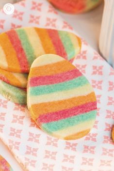 colorful cookies are sitting on a pink and white towel