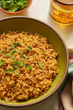 a bowl filled with rice and garnished with cilantro on the side