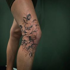 a woman's leg with a flower tattoo on the side of her thigh,