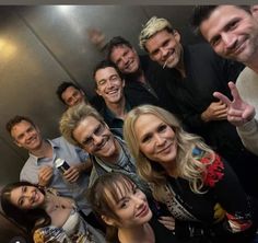 a group of people standing next to each other posing for the camera with their fingers up