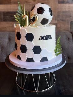 a white and black cake with a soccer ball on top that has the number one on it