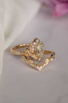 a close up of a ring on top of a white cloth with flowers in the background