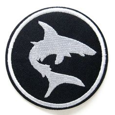 a black and white patch with a shark on it