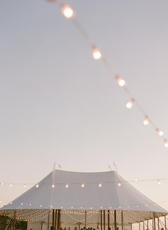 a white tent with string lights hanging from it