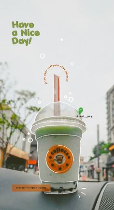 an orange and green drink sitting on top of a car dashboard with the words have a nice day written above it