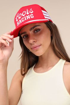 From the racetrack to the beach, the American Needle Coors Talladega Red and White Trucker Hat is a classic for a reason! This instantly iconic hat is the height of cool-girl aesthetics with its padded brim and center panel with ""Coors Racing"" emblazoned across the front. Nylon cord accents the brim, and seamed stripes decorate the sides. Mesh-paneled design creates a perfectly breathable fit. Adjustable snaps at back. 2. 75" Hard Brim. Adjustable 22. 5" Interior Circumference. 100% Polyester. Retro Red Summer Hats, Adjustable Red Baseball Cap For Beach, Adjustable Red Baseball Cap For The Beach, Red Summer Baseball Cap, Trendy Red Snapback Hat For Summer, Red Trucker Hat For Beach, Red Trucker Hat For The Beach, Retro Sports Hats For Summer, Red Beach Cap