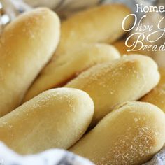 bread rolls in a basket with the words homemade olive bread bread written on it and powdered sugar sprinkled over them