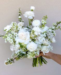 a person holding a bouquet of white flowers