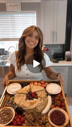 a woman is holding a tray full of food