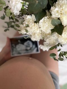 a pregnant woman holding flowers in her belly with an x - ray image on it