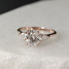 a three stone diamond ring on top of a white marble slab with text overlay that says, how to choose the best engagement ring for your body type