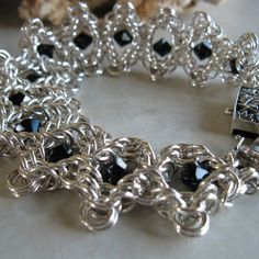 Welcome To My Posh Market! I’m Georgia Siegfried And My Brand Is “Georgia Elizabeth.” I Have Been Handcrafting Artisan Sterling Silver Jewelry Since 2006. I Made This Lovely Chainmail Bracelet In The Dunes Weave, From 18 Gauge, 100% Argentium Sterling Silver Jump Rings, Which I Make From Argentium Wire. The Bracelet’s Is Embellished With Black Swarovski Crystals. Its Length Is 7" And It Contains 54 Grams Of Argentium Sterling Silver. It Has An Ornate Rectangular Box Clasp. Chainmail Jewelry Is Made By Connecting Jump Rings One At A Time. The Process Embodies Patience, Precision, Artistry, And Most Importantly, A Love Of Taking Precious Metal And Beautiful Stones, And Transforming Elegant Black Chain Bracelet With Silver Chain, Silver Bracelet With Black Diamonds For Formal Occasions, Handmade Silver Chain Bracelet For Party, Elegant Chainmail Chain Link Jewelry, Elegant Black Chainmail Jewelry, Silver Metal Bracelets For Evening, Elegant Silver Chain Bracelet For Jewelry Making, Silver Jubilee Bracelet Jewelry For Evening, Elegant Handmade Black Chain Bracelet