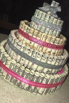 a cake made out of dollar bills with a bow on top and glitter ribbon around it