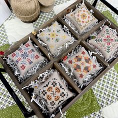 an old wooden box filled with different types of decorative pillows on top of a green and white checkered table cloth