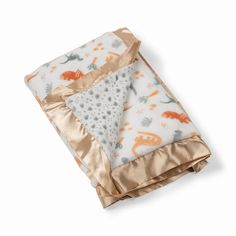 a baby blanket with an orange and white animal print on it's coverlet