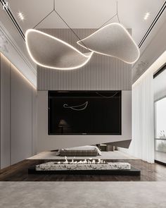 a modern living room with white walls and wood flooring is lit by suspended lights