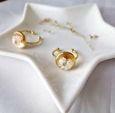 two pairs of earrings sitting on top of a white plate