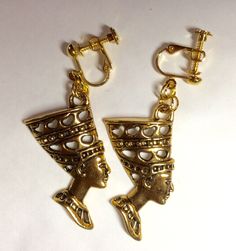 A fabulous pair of handmade Egyptian style Nefertiti gold tone large earrings screw fittings Nerfertiti Queen of Egypt the beautiful mysterious historical queen Simple, charming dangle earrings with screw fittings for non pierced ears The earrings are stamped metal and the charms single sided Please note that both charms face the same way, they are not a mirrored pair. See also other earrings in raw brass with similar Egyptian Nile styling Lovely earrings , an ideal present . Measurement :  head 4 cm long and 2cm across;  dangle is 4.5 cm Lovely earrings , an ideal quirky present . Measurement : charm 3.5 cm long and 2cm across Antique Gold Dangle Plug Earrings, Antique Gold Dangle Clip-on Earrings, Brass Clip-on Drop Earrings, Clip-on Brass Drop Plug Earrings, Gold Ornate Clip-on Earrings, Vintage Gold Dangle Plug Earrings, Gold Vintage Style Dangle Plug Earrings, Antique Gold Drop Clip-on Earrings, Vintage Gold Plug Earrings With Ear Wire