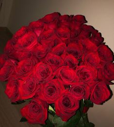 a large bouquet of red roses in a vase