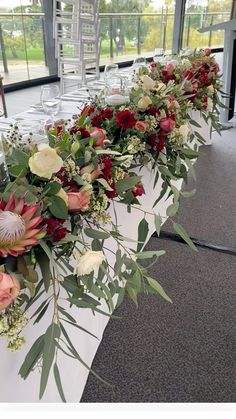 a long table with flowers and greenery on it