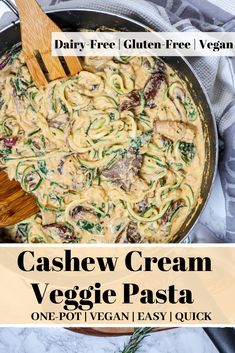 a skillet filled with pasta and spinach on top of a marble countertop