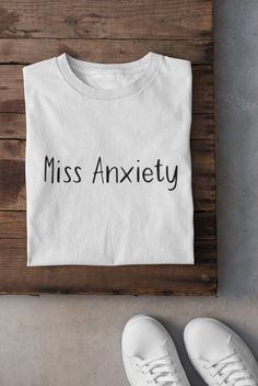 "Do you ever feel like you're living with a constant sense of worry and dread? Like you're always waiting for the other shoe to drop? We know the feeling, and that's why we created the \"Miss Anxiety\" t-shirt! This simple text tee is perfect for anyone who's ever experienced anxiety - whether it's a passing feeling or a constant companion. With its cute, sarcastic design, this t-shirt is a fun way to express your anxiety and make light of a difficult situation. Wear it to your next therapy session, to the grocery store, or even to bed - we won't judge! The shirt is made from comfortable, high-quality material that's perfect for casual wear. So why not embrace your anxious side with this stylish and relatable t-shirt? We promise it'll be the most comfortable thing you wear all day. Plus, i Text T Shirt, Text Tee, Counting Cards, Quote Tees, Mothers Day Shirts, Blackjack, Unisex Tshirt, Text Design, Shirts With Sayings