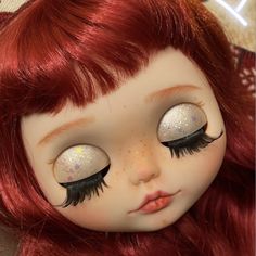 a doll with long red hair and glitter eyes