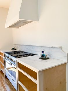 a stove top oven sitting inside of a kitchen next to wooden cabinets and counter tops