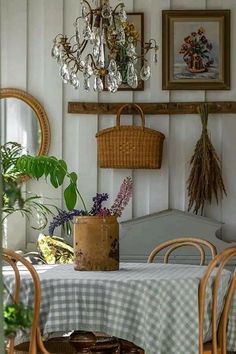 a dining room table with chairs and a chandelier hanging from it's ceiling