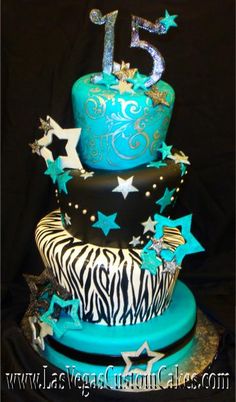 a three tiered cake with zebra print and blue icing, stars and numbers