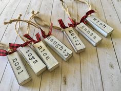 four wooden blocks with words on them hanging from twine strings, tied to wood planks