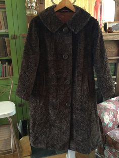 This is a lovely coat made of faux fur in a soft medium brown with a sculpted design in the fabric. It has the original buttons, two front pockets and a full lining. In excellent condition. The measurements, taken with the coat lying flat, are: shoulder to shoulder, 20 inches; armpit to armpit, 24 inches; sleeves, 22 1/2 inches; total length, 44 inches; bottom edge, 26 inches. Brown Fur Coat With Buttons For Fall, Brown Winter Fur Coat With Button Closure, Brown Fur Coat With Button Closure For Fall, Vintage Brown Faux Fur Outerwear, Retro Brown Faux Fur Coat, Vintage Long Coat In Faux Fur, Vintage Brown Outerwear With Faux Fur Trim, Brown Vintage Fur Coat With Faux Fur Trim, Vintage Outerwear