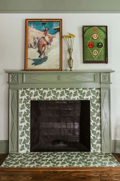 a fireplace in a living room with paintings on the wall and a painting above it