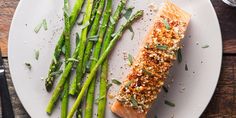 a white plate topped with asparagus and salmon