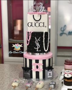 a three tiered cake is decorated with black and white stripes, pink accents, and pearls