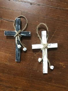 two wooden crosses tied with twine on top of a wooden table next to each other