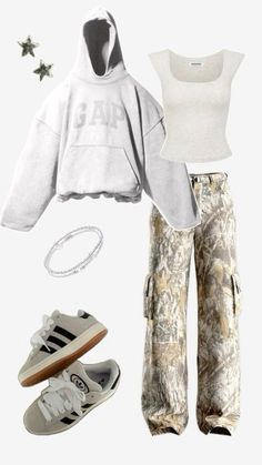 a white shirt and camouflage pants are outfitted with adidas sneakers, a hoodie, and star - studded bracelets