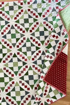 two quilts sitting on top of each other in the middle of a wooden floor