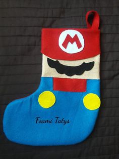 a blue stocking with a red hat and mustache on it's face is sitting on a black background